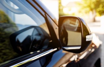 the rear view mirror of a black car.