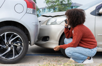 women driver check for damage after a car accident
