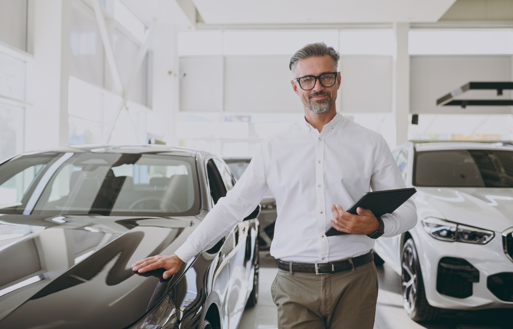 Adult man customer male buyer client wears shirt hold clipboard with papers documents choose auto want to buy new automobile in car showroom vehicle salon dealership store motor show. Sales concept